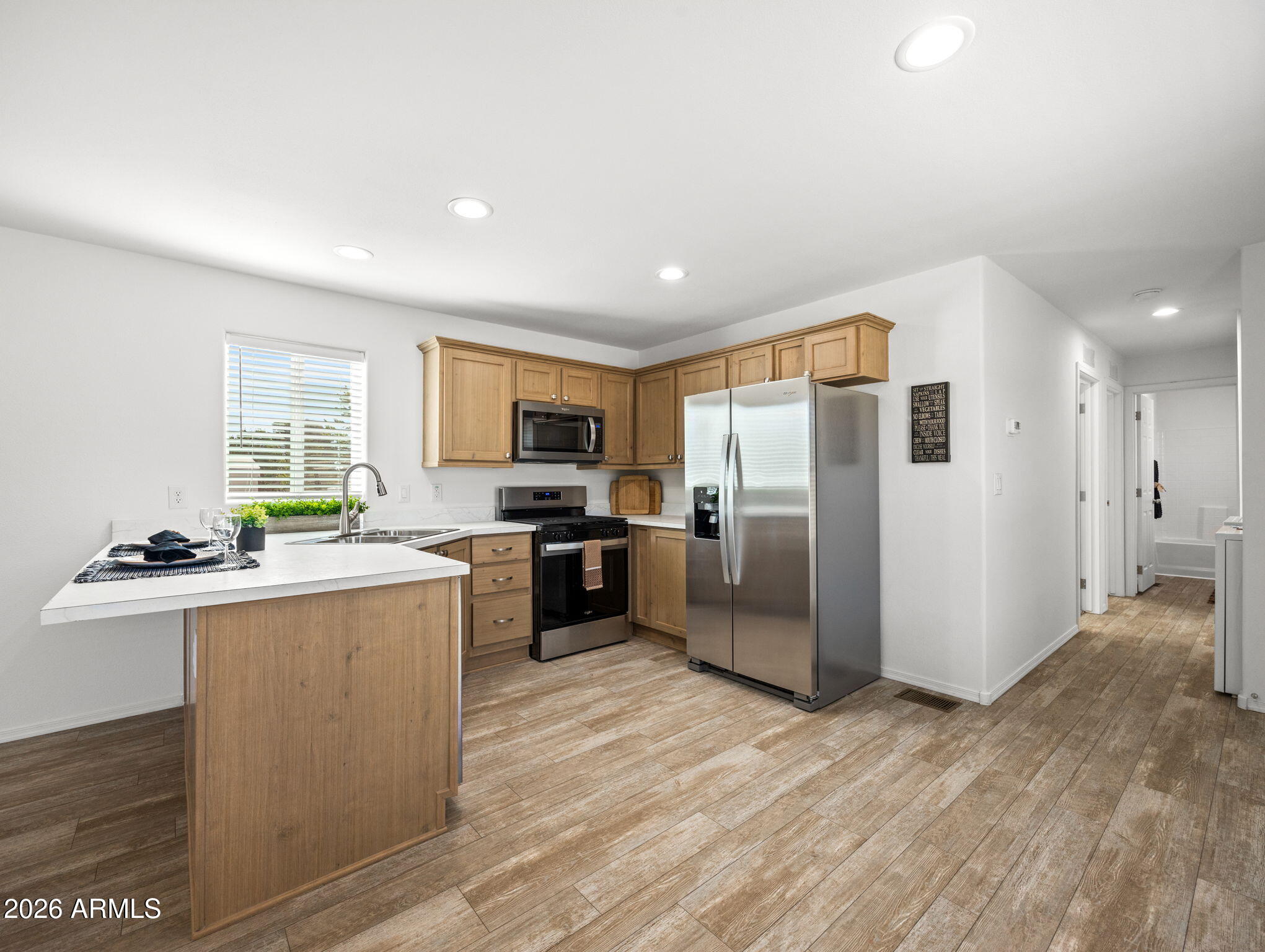 18296 Frontier Road Peeples Valley, AZ 86332 - Photo 11 of 44 a kitchen with stainless steel appliances granite countertop a refrigerator a stove top oven a sink dishwasher and wooden floor