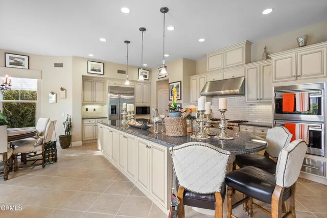 a kitchen with stainless steel appliances kitchen island granite countertop a sink and a refrigerator