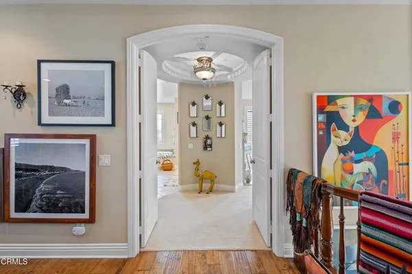 a view of a hallway with wooden floor and furniture