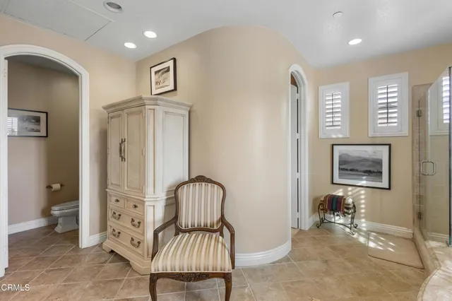 a view of a hallway with bathroom view and mirror