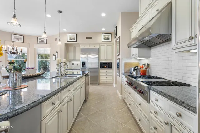 a large kitchen with stainless steel appliances granite countertop a stove a sink and a granite counter tops