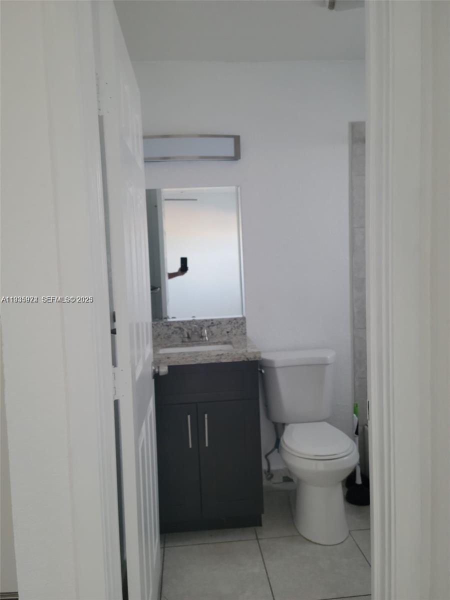 5655 Johnson Street, Unit 2 Hollywood, FL 33021 - Photo 4 of 8 a bathroom with a granite countertop toilet and a sink