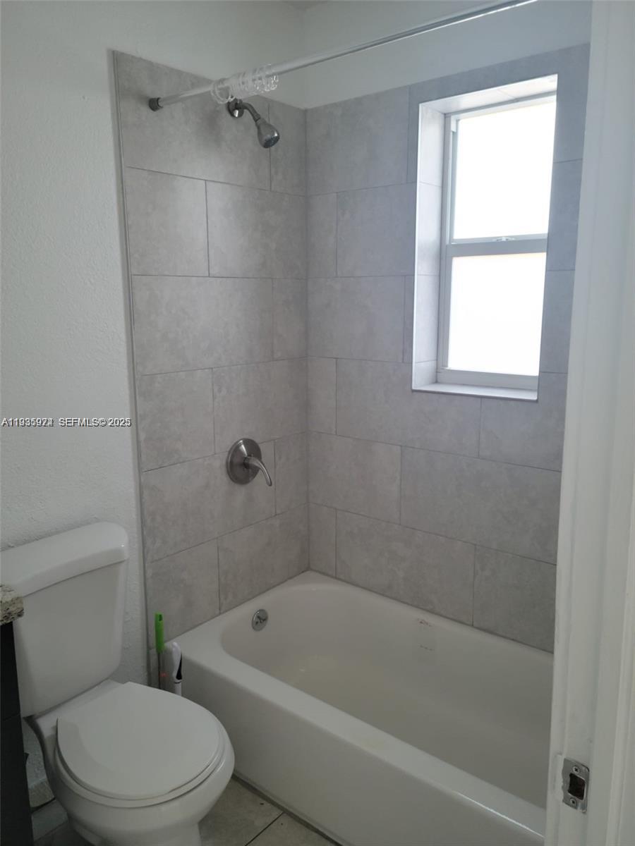 5655 Johnson Street, Unit 2 Hollywood, FL 33021 - Photo 5 of 8 a white bath tub sitting next to a toilet