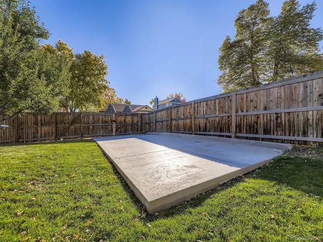 a view of a backyard with a small cabin and wooden fence