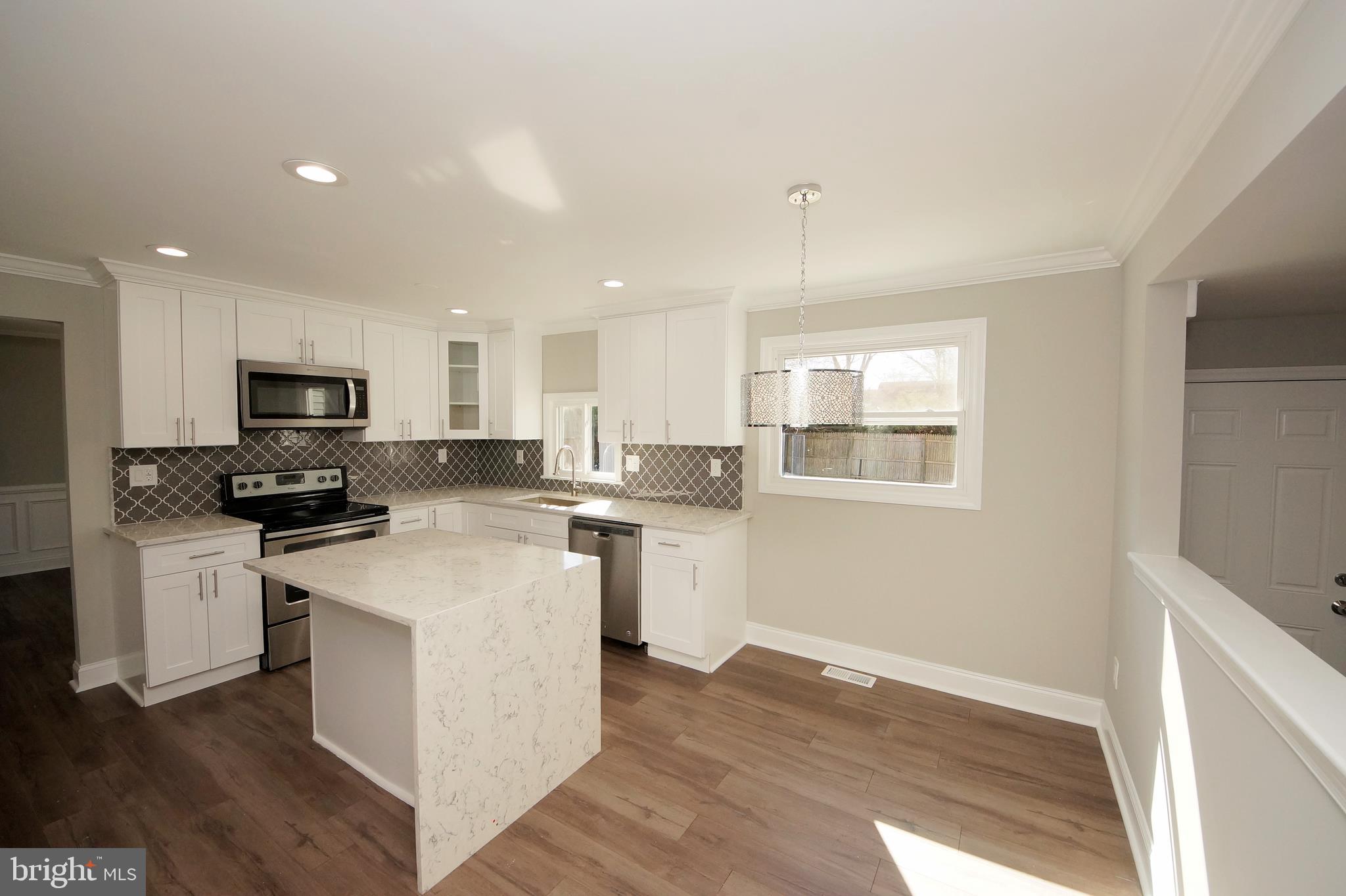 109 Coopers Kill Road Delran, NJ 08075 - Photo 14 of 35 a kitchen with a sink wooden floor and white cabinets