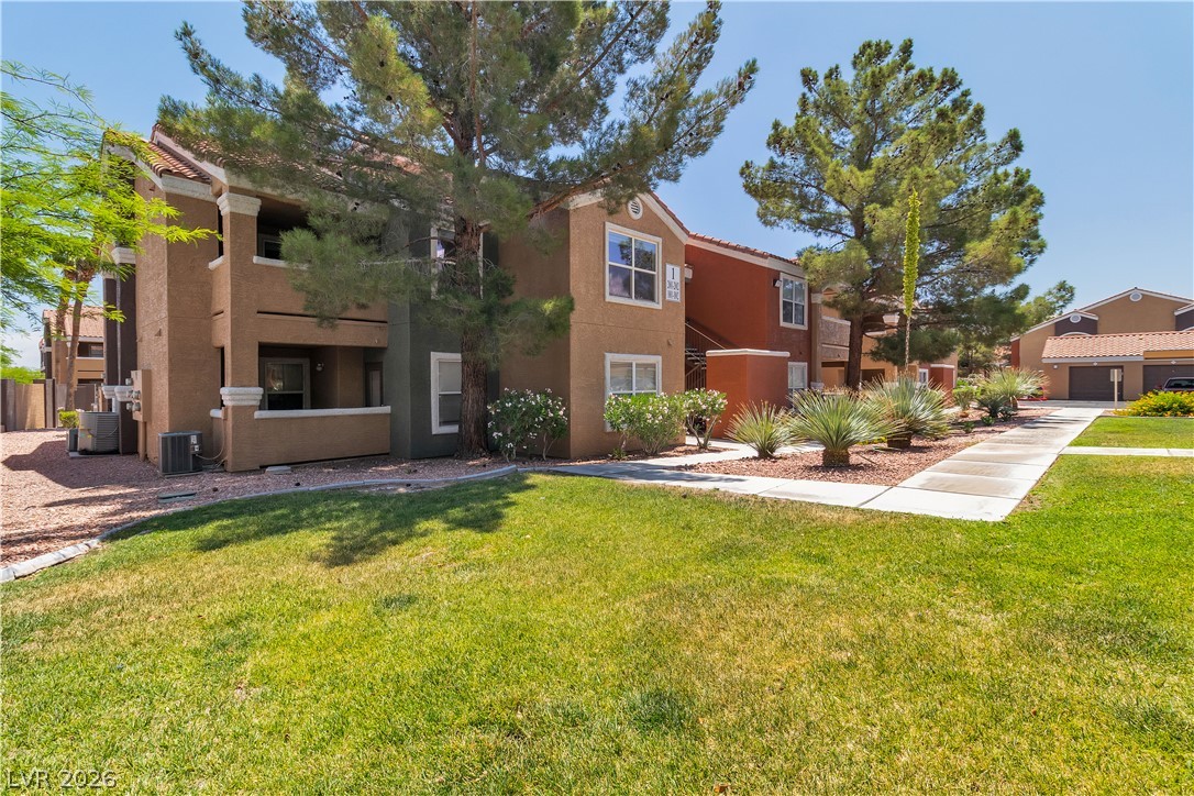 8101 West Flamingo Road, Unit 2001 Las Vegas, NV 89147 - Photo 2 of 28 A well-maintained landscape frames these welcoming multi-story apartment buildings, offering a pleasant living environment.