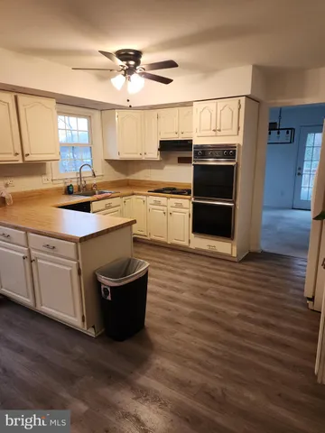 a kitchen with kitchen island granite countertop a sink and cabinets