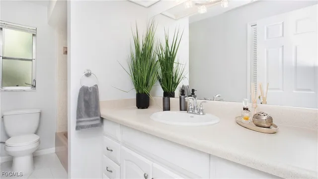 a bathroom with a granite countertop sink a toilet and with mirror