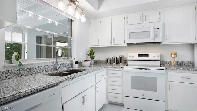 a kitchen with white cabinets and white appliances