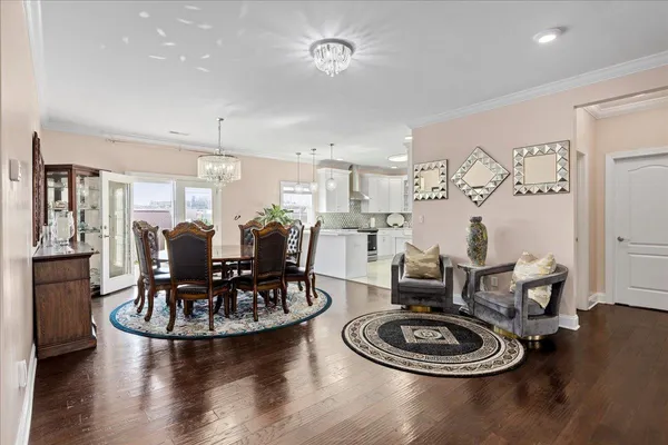 a view of a dining room with furniture a chandelier and wooden floor