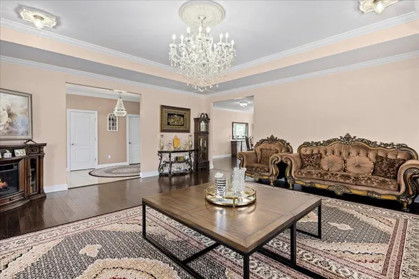 a living room with furniture a chandelier and a table