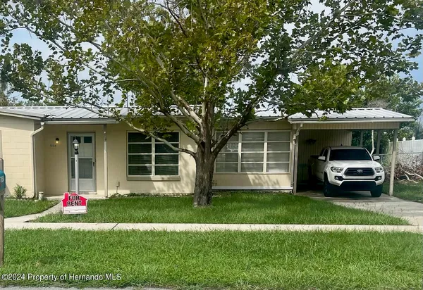 a view of a house with a yard and sitting area