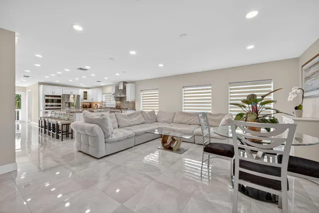 a living room with furniture kitchen view and a flat screen tv