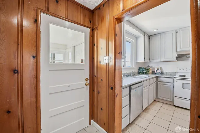 a kitchen with white cabinets and white appliances