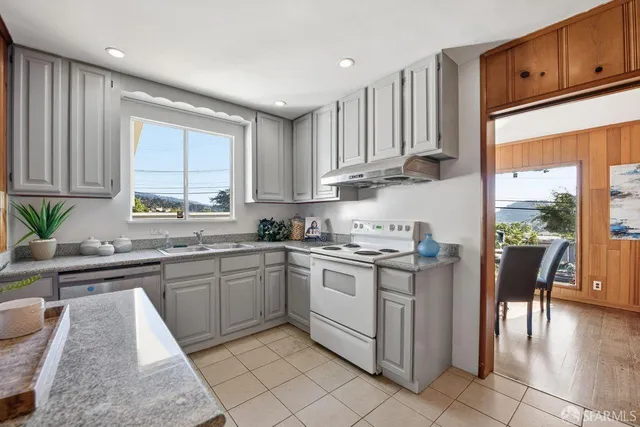 a kitchen with a stove sink and cabinets