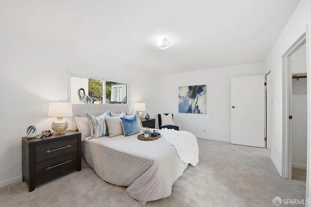 a bedroom with a bed and painting on the wall