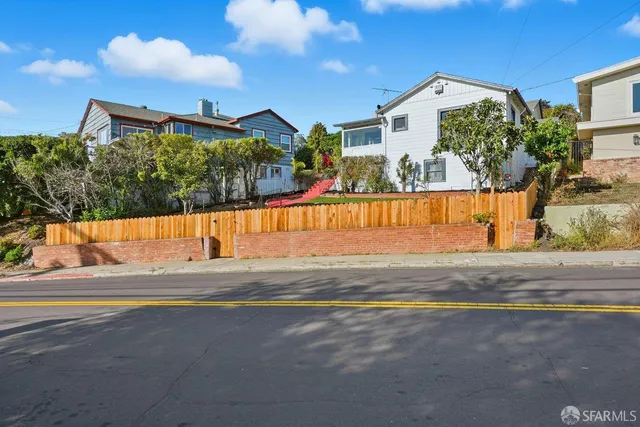 a view of a house with a yard and sitting area