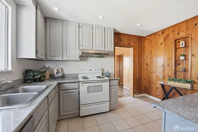 a kitchen with a stove sink and cabinets