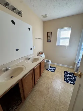 a bathroom with a double vanity sink a mirror and a bathtub