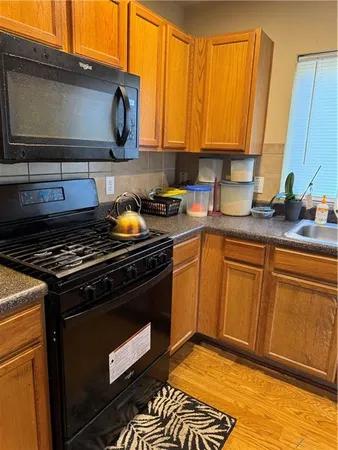 a kitchen with stainless steel appliances granite countertop a stove a sink and a microwave