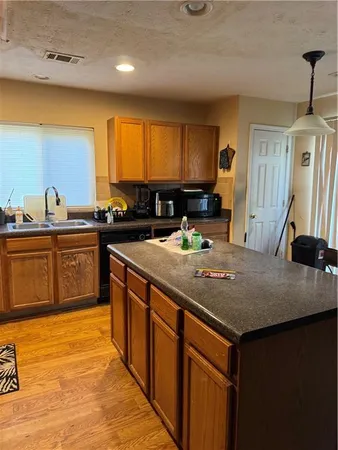 a kitchen with kitchen island granite countertop a sink counter top space and cabinets