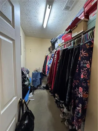 a view of walk in closet with clothes