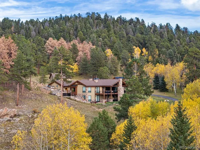 an aerial view of a house with swimming pool and mountain view