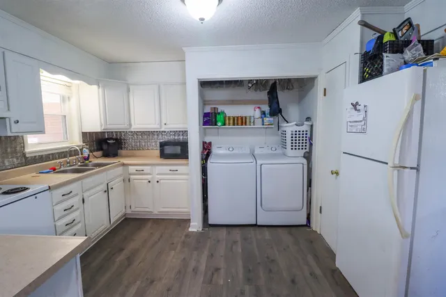 a kitchen with a refrigerator a sink and dishwasher with wooden floor