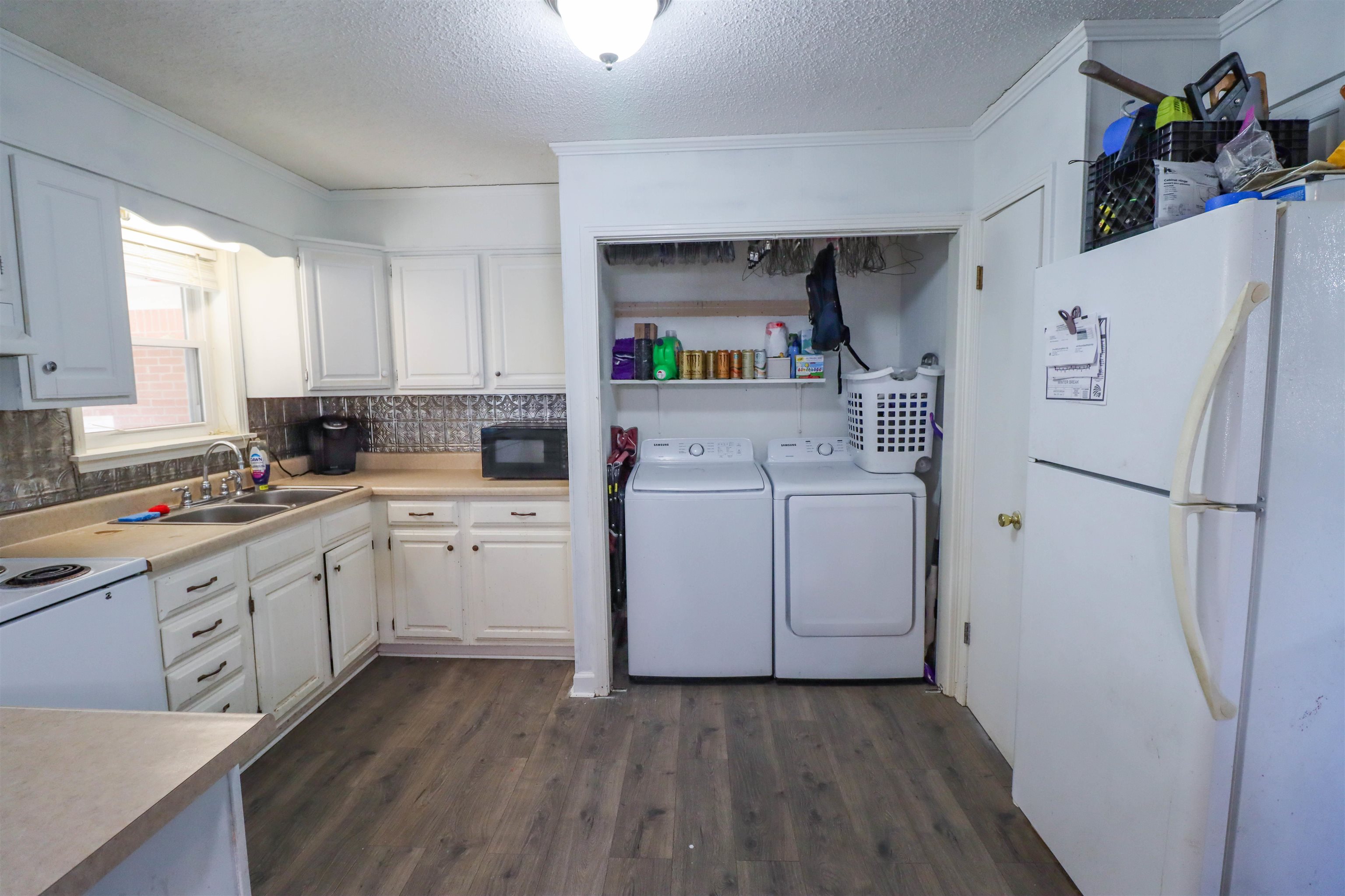 211 Washington Street Newbern, TN 38059 - Photo 21 of 28 a kitchen with a refrigerator a sink and dishwasher with wooden floor