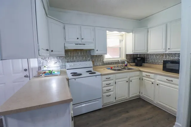 a kitchen with cabinets appliances a sink and a window