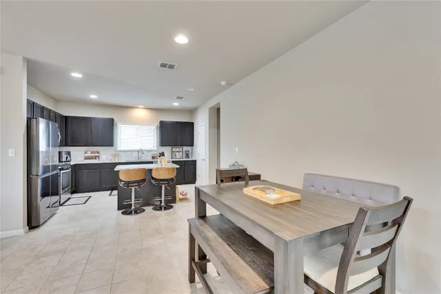 a kitchen with a table chairs sink and white cabinets