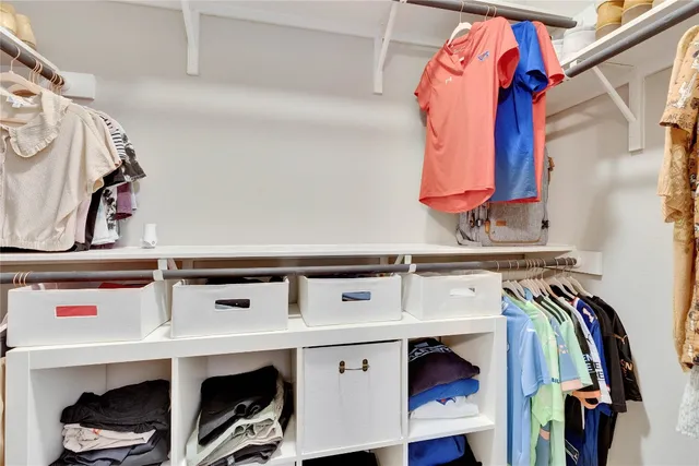 a view of walk in closet with clothes and shoes