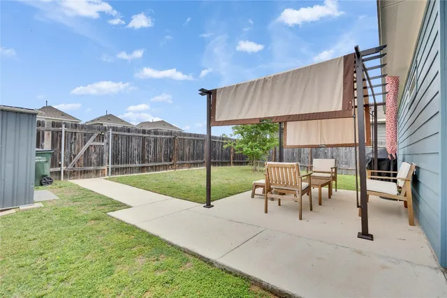 a view of a house with backyard and sitting area