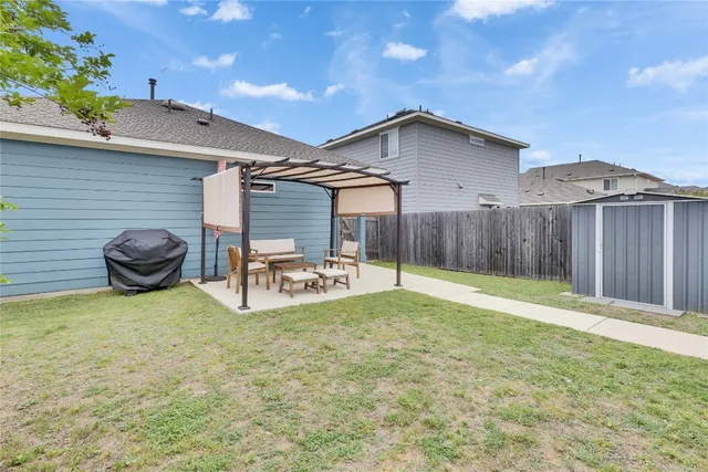 a view of a backyard with table and chairs and wooden fence