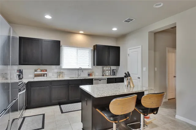 a kitchen with granite countertop a sink and a refrigerator