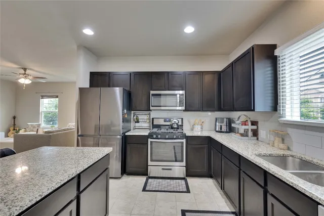 a kitchen with a sink a refrigerator and cabinets