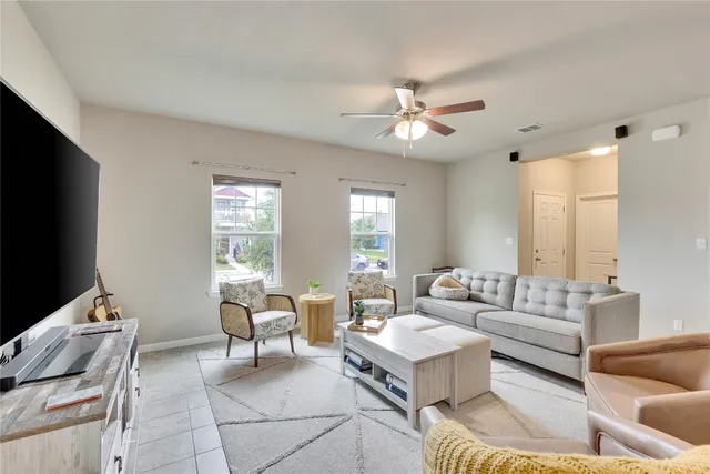 a living room with furniture a flat screen tv and a window