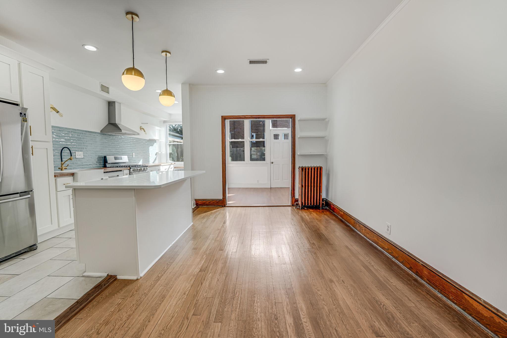 1304 Rittenhouse Street Northwest Washington, DC 20011 - Photo 12 of 50 a kitchen with stainless steel appliances granite countertop a stove a sink and white cabinets with wooden floor