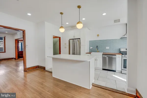 a kitchen with appliances a sink and cabinets