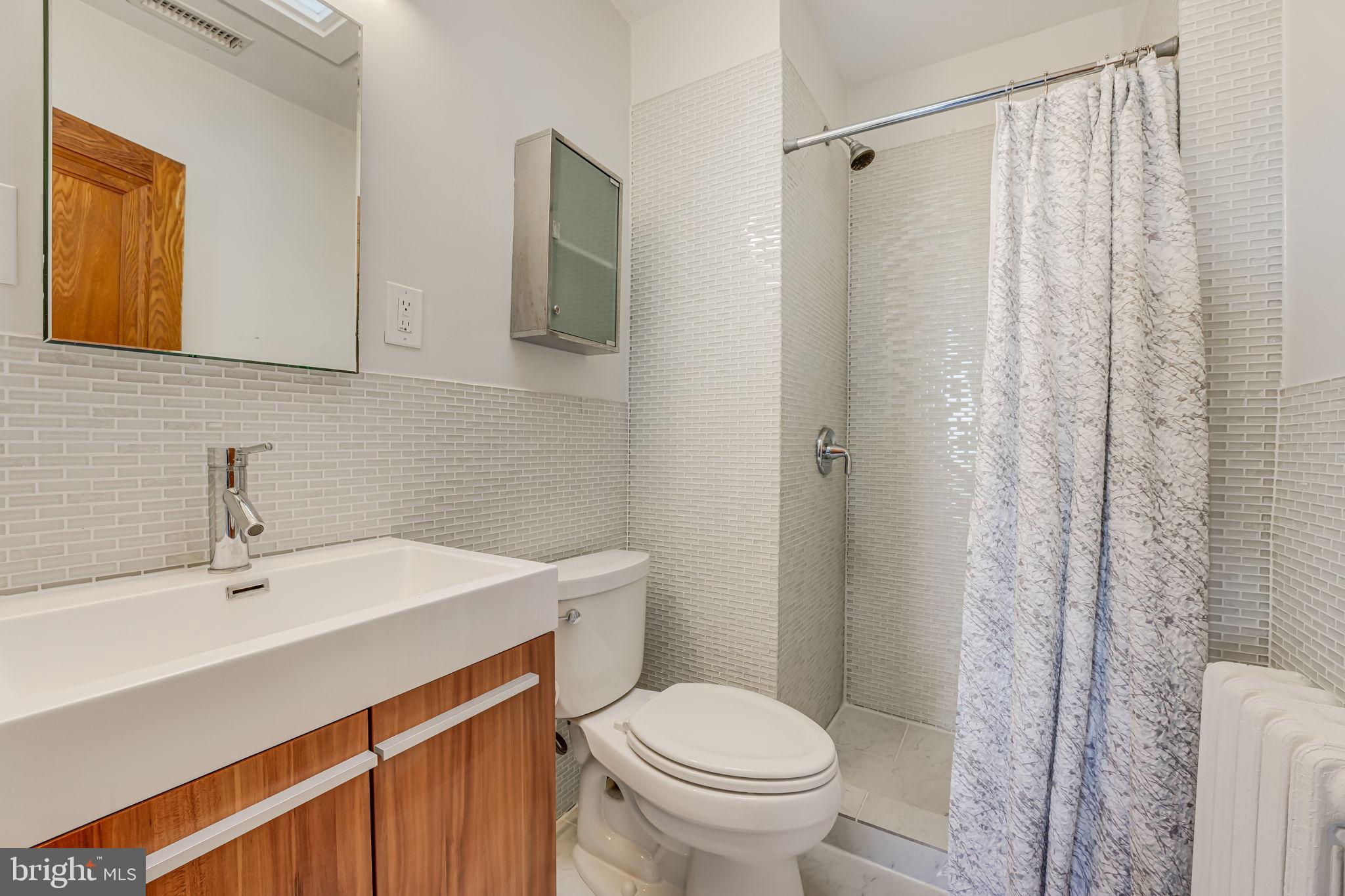 1304 Rittenhouse Street Northwest Washington, DC 20011 - Photo 30 of 50 a bathroom with a sink a toilet and shower