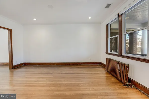 a view of an empty room with wooden floor