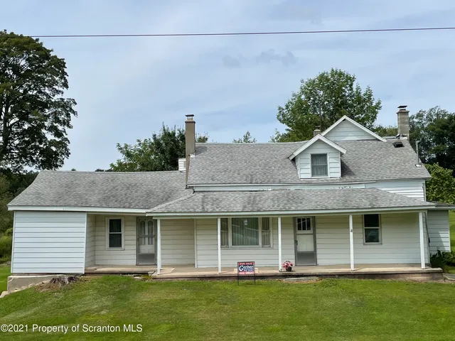 a front view of a house with a garden and plants