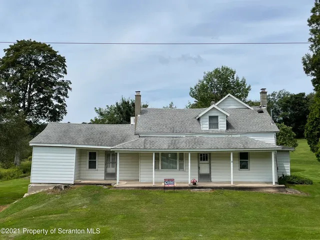 a view of a house with a yard and sitting area