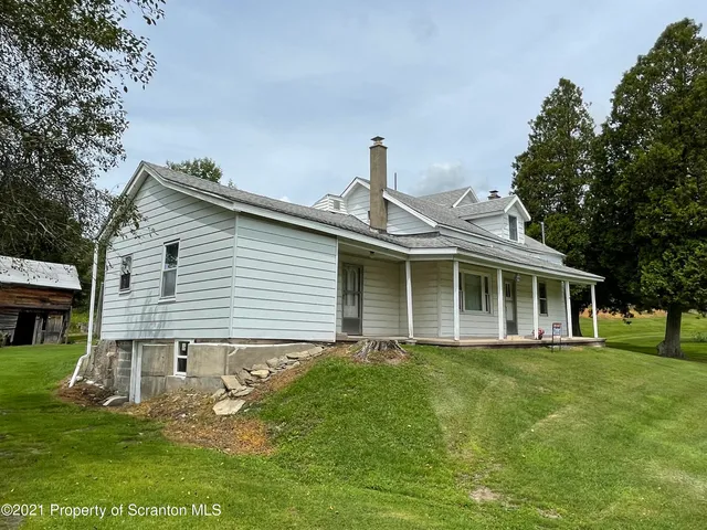 a view of a house with a yard and sitting area