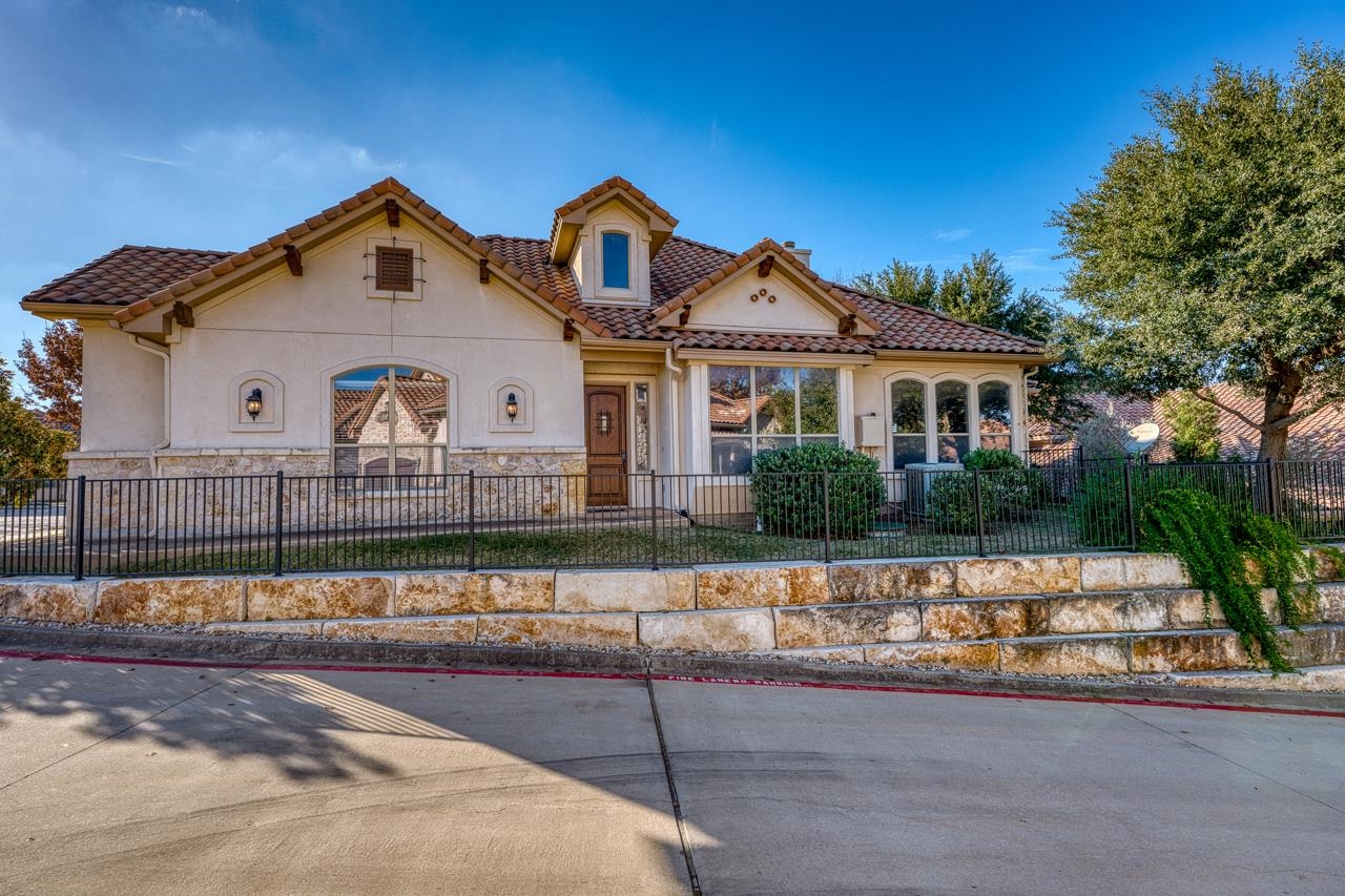 300 Enclave Circle Horseshoe Bay, TX 78657 - Photo 1 of 30 a view of a white house next to a yard with large trees