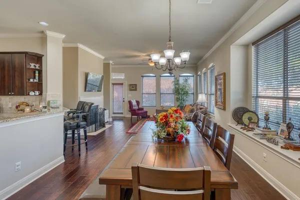 a view of a dining room and livingroom furniture wooden floor a chandelier
