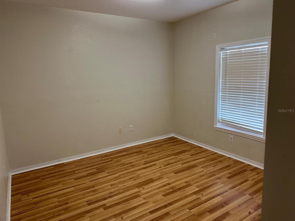 3757 Conroy Road, Unit 2512 Orlando, FL 32839 - Photo 12 of 13 a view of an empty room with wooden floor and a window