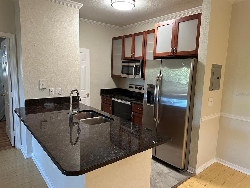 3757 Conroy Road, Unit 2512 Orlando, FL 32839 - Photo 3 of 13 a kitchen with stainless steel appliances granite countertop a sink and a refrigerator