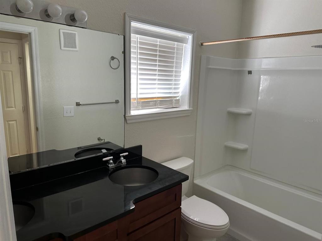 3757 Conroy Road, Unit 2512 Orlando, FL 32839 - Photo 10 of 13 a bathroom with a sink a toilet and shower
