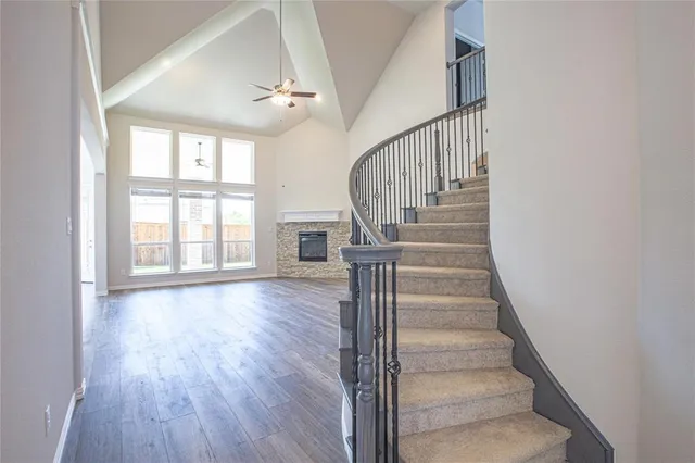 a view of staircase with wooden floor and fan
